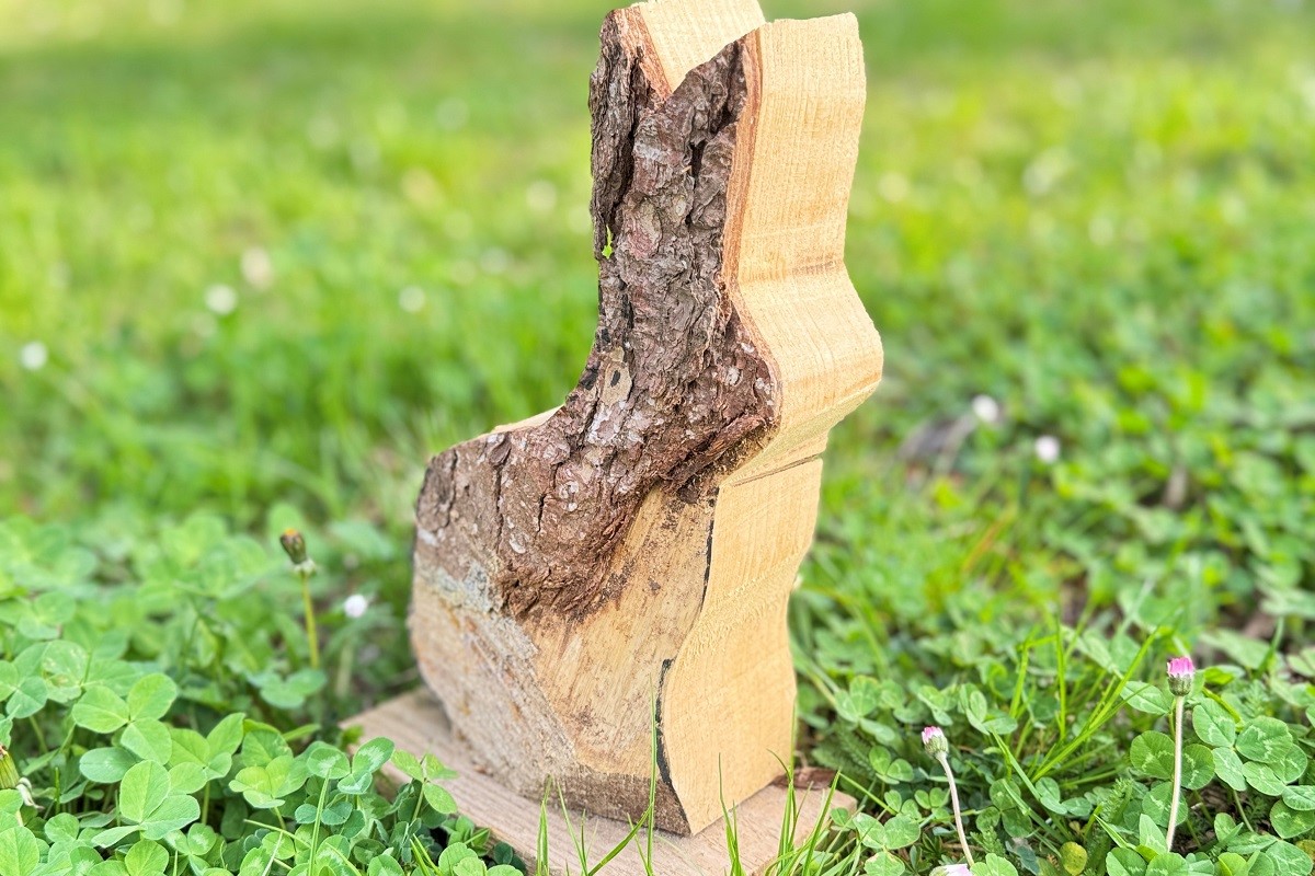 Osterhase aus Holz steht am Baum