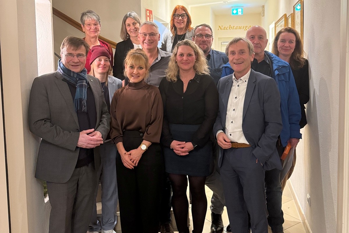Gruppenfoto der Geehrten mit Vertreter der KJF und Gesamtleiter Frank Baumgartner zu sehen vor der Treppe im Gasthof Kuchlabuer