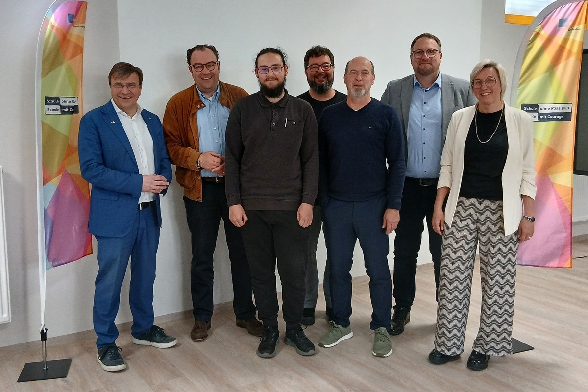 Gruppenfoto bei der Feier stehend vor den Beachflag Schule ohne Rassismus