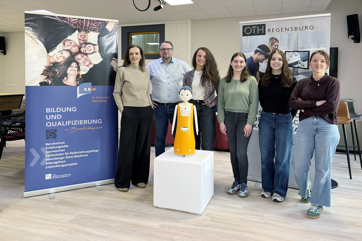 Gruppe von Menschen stehen um den Roboter Navel 